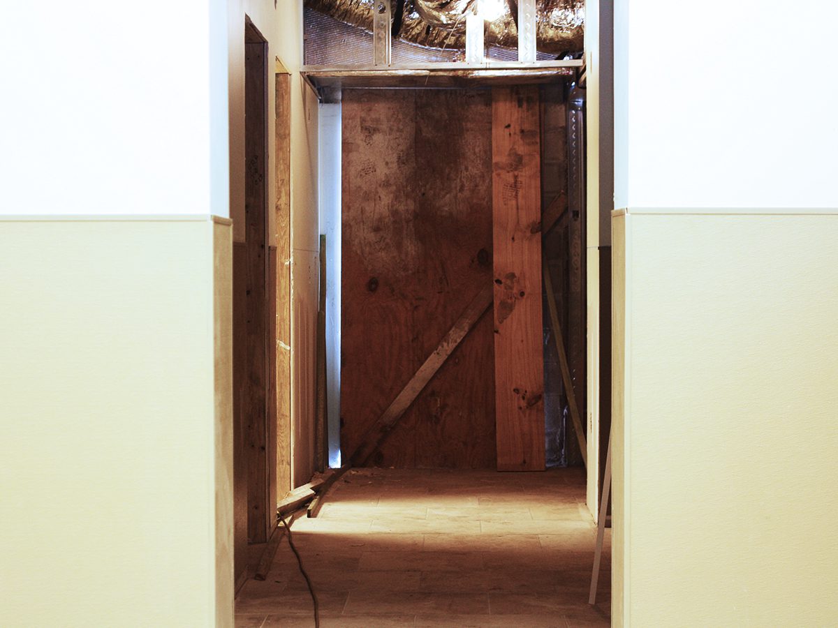 A doorway leading to the basement of an unfinished house.