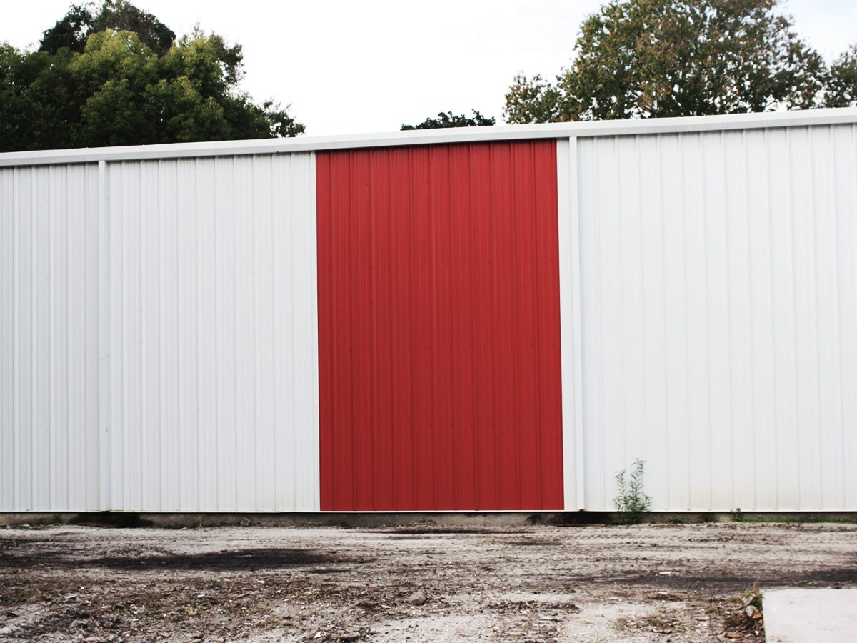 A red and white building with a door open.