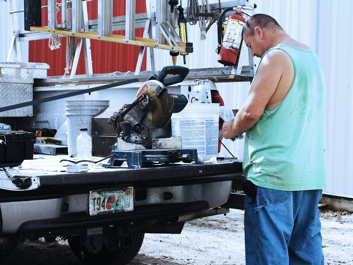 A man working on a truck with a machine.