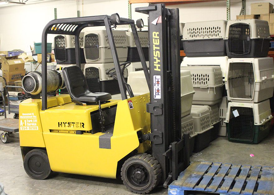 A yellow forklift is parked in front of some crates.