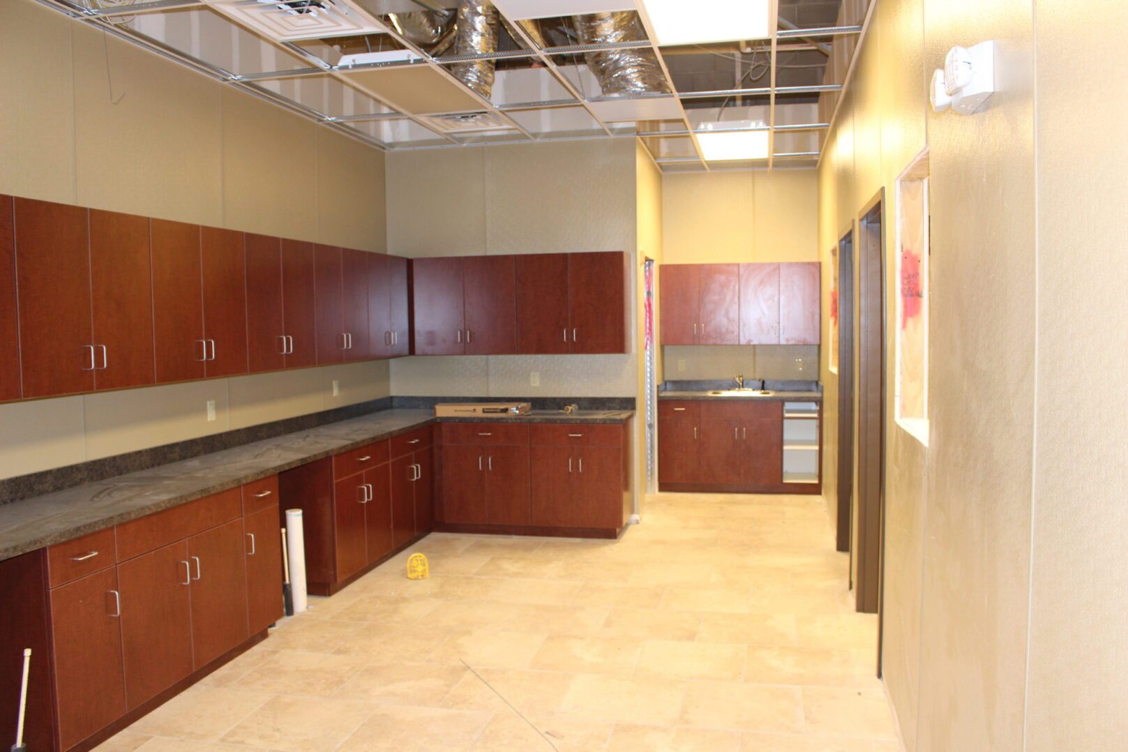 A kitchen with brown cabinets and tile floors.